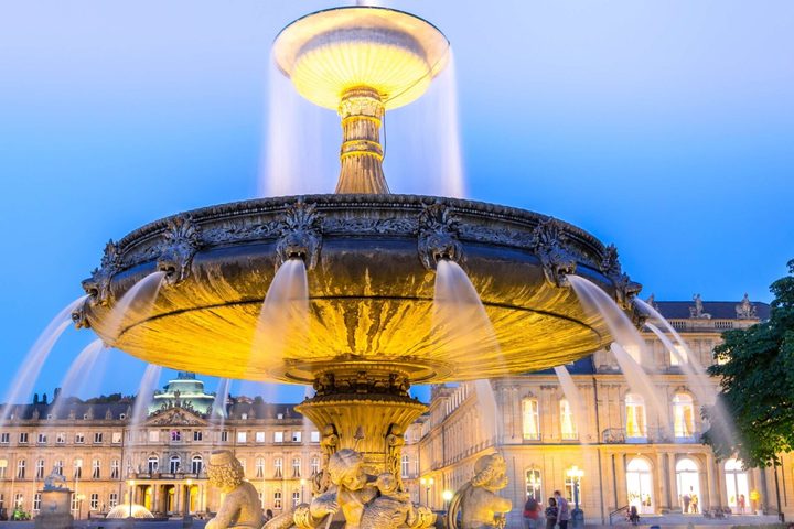 Beleuchteter Brunnen auf dem Stuttgarter Schlossplatz am Abend